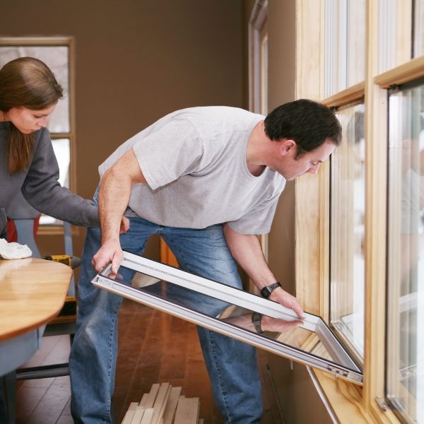 two people installing energy efficient windows